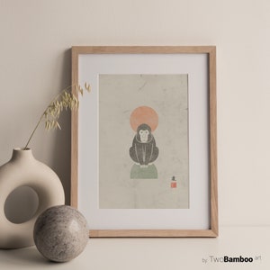 May include: A framed print of a black and white illustration of a monkey sitting on a green rock with a red sun behind it. The print has the Japanese character for "monkey" in red ink in the bottom right corner. The print is framed in a light wood frame.