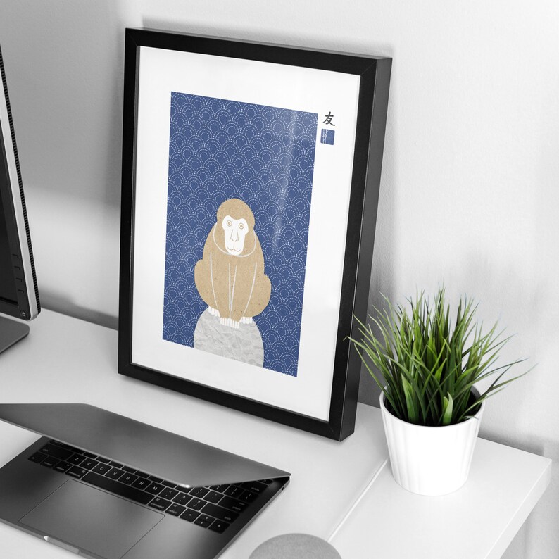 May include: A framed print of a monkey sitting on a rock with a blue and white patterned background. The Japanese word "友" is printed in the top right corner of the print.
