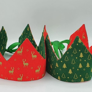 May include: Two festive paper crowns, one red with gold reindeer and stars, the other green with gold Christmas trees and stars.