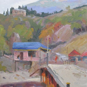 May include: A painting of a small pink house with a blue roof, set against a backdrop of rolling hills and a distant mountain range. The house is situated on a path leading to a bridge, with a lamppost and a few trees in the foreground.