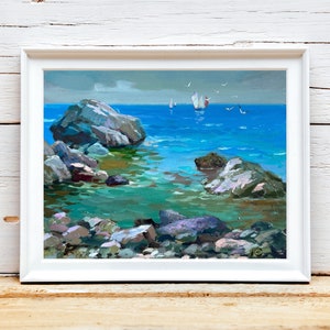 Puede incluir: Una pintura al óleo de un paisaje marino con grandes rocas grises en primer plano y agua turquesa clara. Se ven veleros y gaviotas a lo lejos bajo un cielo nublado. La obra de arte está enmarcada en un marco rectangular blanco.