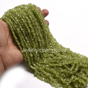 May include: A strand of green peridot gemstone beads, faceted and chipped, for jewelry making.