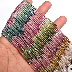 Puede incluir: Una hebra de cuentas de turmalina multicolores. Las cuentas son pequeñas y redondas, y están enhebradas en un hilo. Las cuentas son una mezcla de rosa, verde y azul.