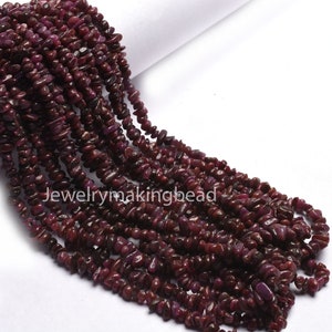 May include: A strand of deep red ruby chip beads. The beads are small and irregular in shape, giving the strand a natural, rustic look.