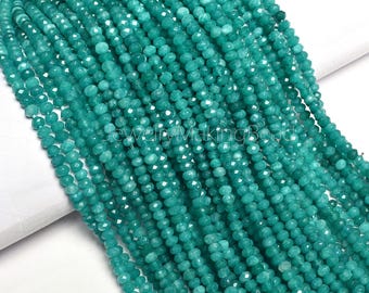 May include: Strands of faceted, teal-colored gemstone beads. The beads are small, round, and strung together, creating a flowing, textured appearance. The image is well-lit, highlighting the beads' color and reflective surfaces. Ideal for jewelry making.