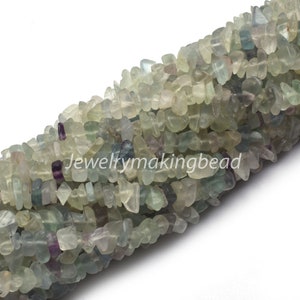 May include: A strand of light green, blue, and purple fluorite chip beads. The beads are irregular in shape and have a natural, tumbled finish.