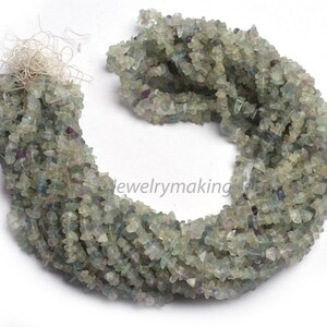 May include: A strand of green, blue, and clear chip fluorite beads. The beads are irregular in shape and have a natural, rough texture.