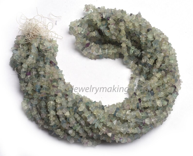 May include: A strand of green, blue, and clear chip fluorite beads. The beads are irregular in shape and have a natural, rough texture.