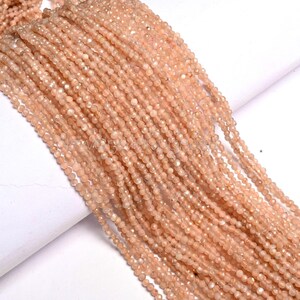May include: Multiple strands of peach-coloured gemstone beads. The small, faceted beads are strung together, creating a flowing, textured appearance. The colour is a soft, warm peach with subtle tone variations, suggesting natural stone. Suitable for jewellery making.