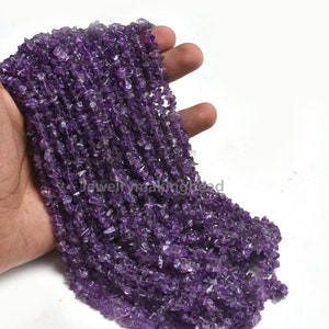 May include: A strand of purple amethyst chip beads. The beads are small and irregular in shape, and they are strung on a clear thread.