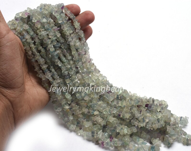 May include: A strand of light green, blue, and purple fluorite chip beads. The beads are irregular in shape and size, and they are strung on a clear thread.