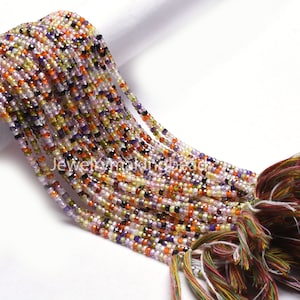 Peut inclure: Un brin de perles de pierres précieuses multicolores, dont l'améthyste, la citrine et le rubis, avec un pompon à l'extrémité. Les perles sont petites et rondes, et le brin mesure environ 38 cm de long.