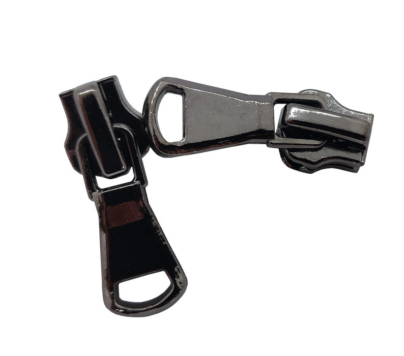 May include: A black metal zipper pull with a slider and a loop. The zipper pull is designed to be used with a zipper on a garment or other item.