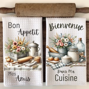 May include: Two white kitchen towels with a floral design and French text. The first towel says "Bon Appetit Mes Amis" and the second towel says "Bienvenue Dans Ma Cuisine".