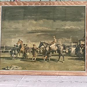 Peut inclure: Une estampe vintage encadr&eacute;e repr&eacute;sentant une sc&egrave;ne de course de chevaux. L'estampe montre un jockey mont&eacute; sur un cheval brun, avec d'autres chevaux et des personnes en arri&egrave;re-plan. La sc&egrave;ne se d&eacute;roule sous un ciel nuageux.