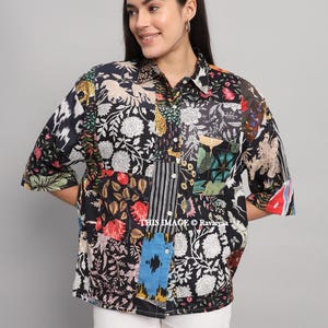Könnte beinhalten: Ein Patchwork-Hemd mit verschiedenen Blumen- und Tiermotiven in Schwarz, Weiß, Rot und Blau. Das Hemd hat kurze Ärmel und einen Kragen. Der Text "THIS IMAGE © Ravaiya" ist sichtbar.