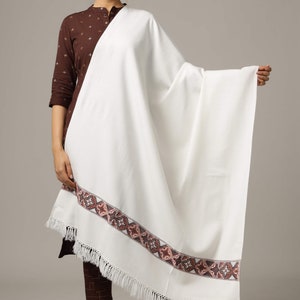 May include: White shawl with a brown and gray embroidered border and white fringe.