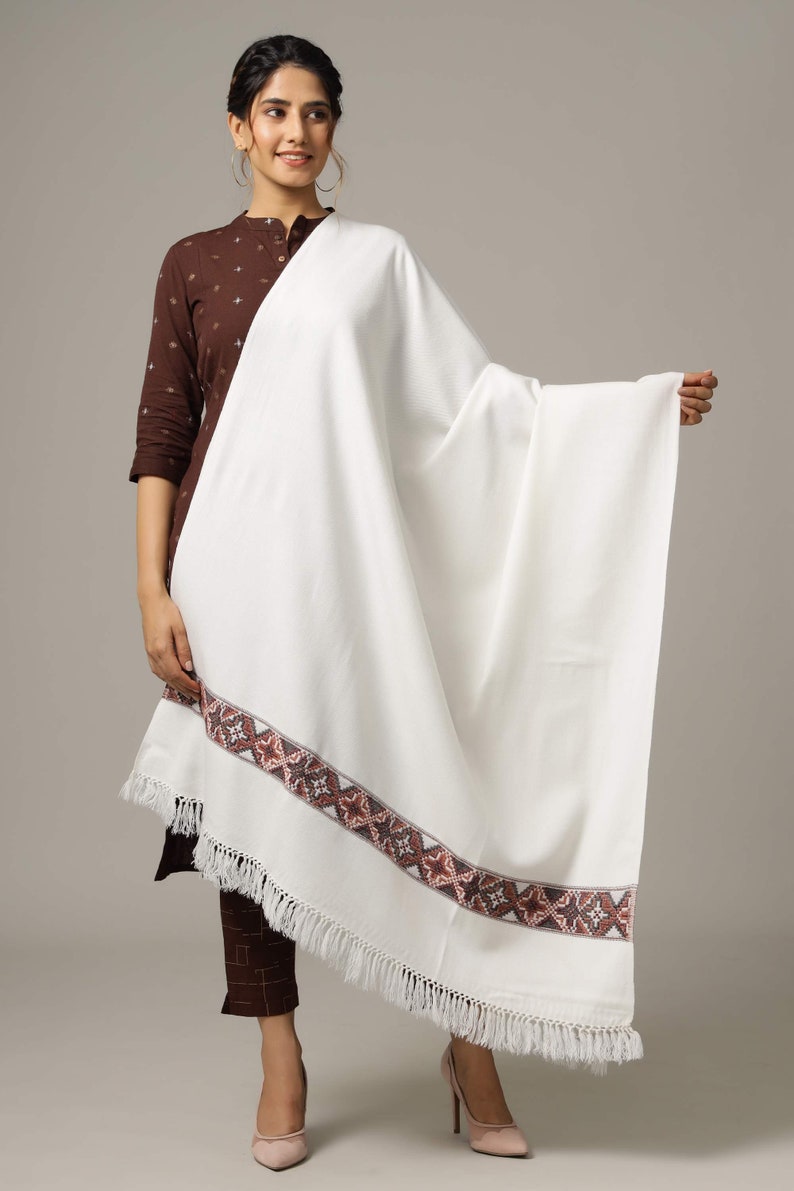 May include: White shawl with a brown and gray embroidered border and white fringe.