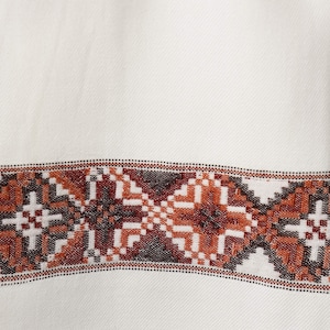 May include: White fabric with a brown and black geometric pattern border.