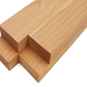 May include: Four pieces of unfinished cherry wood, each measuring 1 x 2 x 12 inches. The wood is light brown in color and has a smooth surface.