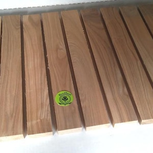 May include: A set of 12 wooden planks, each approximately 12 inches long and 1.5 inches wide. The planks are a light brown color and have a smooth, polished finish. The planks are arranged in a row, with the ends of each plank aligned. The planks are labeled "WoodHaven".