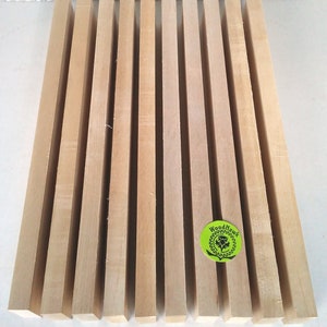 May include: A set of 12 unfinished wooden dowels, each measuring approximately 12 inches in length. The dowels are arranged in a row on a white surface. The dowels are a light brown color and have a smooth, polished finish. The dowels are ideal for crafting projects, such as making furniture, toys, or jewelry.