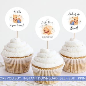 以下が含まれることがあります： 「Rumbly in your tummy?」「A little Hunny is on the way!」「Babies are Sweet!」と書かれた、くまのプーさんモチーフのカップケーキトッパー3個