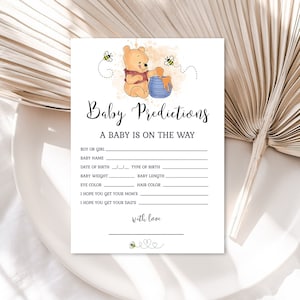 May include: A printable baby shower game card with a cartoon Winnie the Pooh character holding a pot of honey. The card has a title that says "Baby Predictions" and includes lines for guests to write their predictions for the baby's name, date of birth, weight, length, eye color, and hair color.