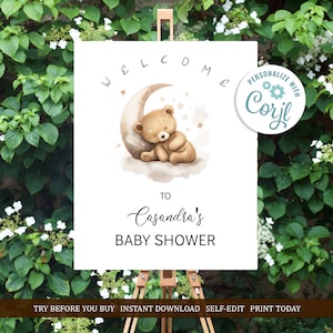 May include: A printable welcome sign for a baby shower with a cute cartoon bear sleeping on a crescent moon. The sign says "Welcome to Casandra's Baby Shower".
