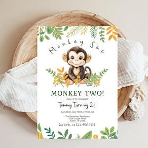 Puede incluir: Una invitación de cumpleaños con un mono de dibujos animados que lleva una camisa verde y está sentado en un lecho de hojas verdes y amarillas. La invitación dice "Monkey See Monkey Two!" e incluye el texto "Join us to celebrate Tommy Turning 2!" La invitación también incluye la fecha, la hora y el lugar de la fiesta.