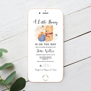 May include: A Winnie the Pooh themed baby shower invitation with a cartoon illustration of Winnie the Pooh holding a pot of honey. The invitation text reads "A Little Hunny is on the way" and includes the name Jamie Walker, the date and time of the shower, the location, and RSVP information. The invitation also includes the text "Registered at Amazon and Target".