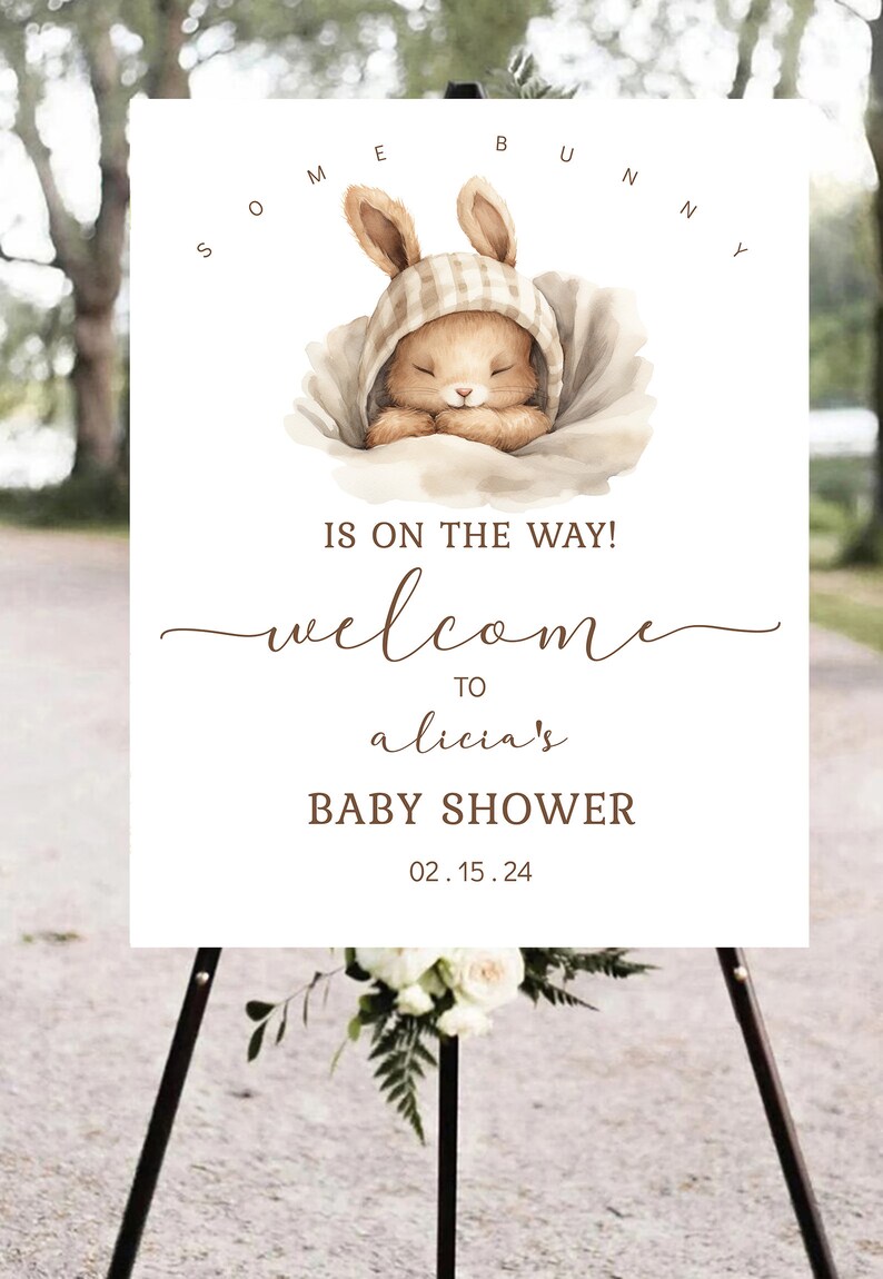 K&ouml;nnte beinhalten: Ein wei&szlig;es Schild mit einer braunen Hasenillustration und dem Text "Some Bunny is on the way! Welcome to Alicia's Baby Shower 02.15.24".