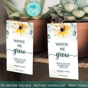 May include: Two white rectangular tags with floral designs and the text "Watch Me Grow". The tags are attached to small potted plants. The text "Thank you for celebrating with us!" is also included.