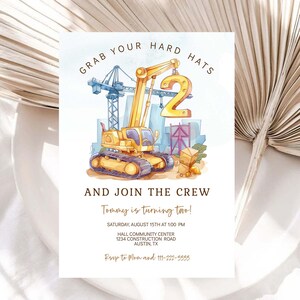 May include: Construction themed birthday invitation with a yellow crane lifting a gold number 2. The invitation says "Grab your hard hats and join the crew! Tommy is turning two!" with details for the party.