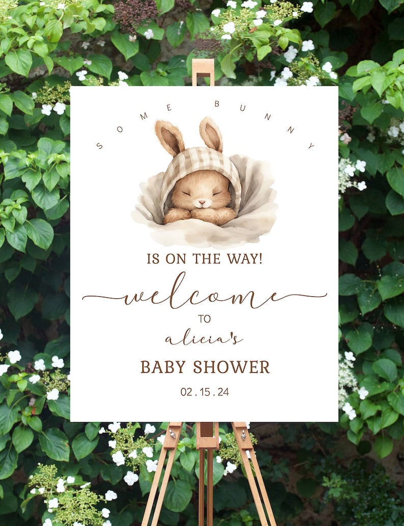 K&ouml;nnte beinhalten: Ein wei&szlig;es Schild mit einer braunen Hasenillustration und dem Text "Some Bunny is on the way! Welcome to Alicia's Baby Shower 02.15.24".