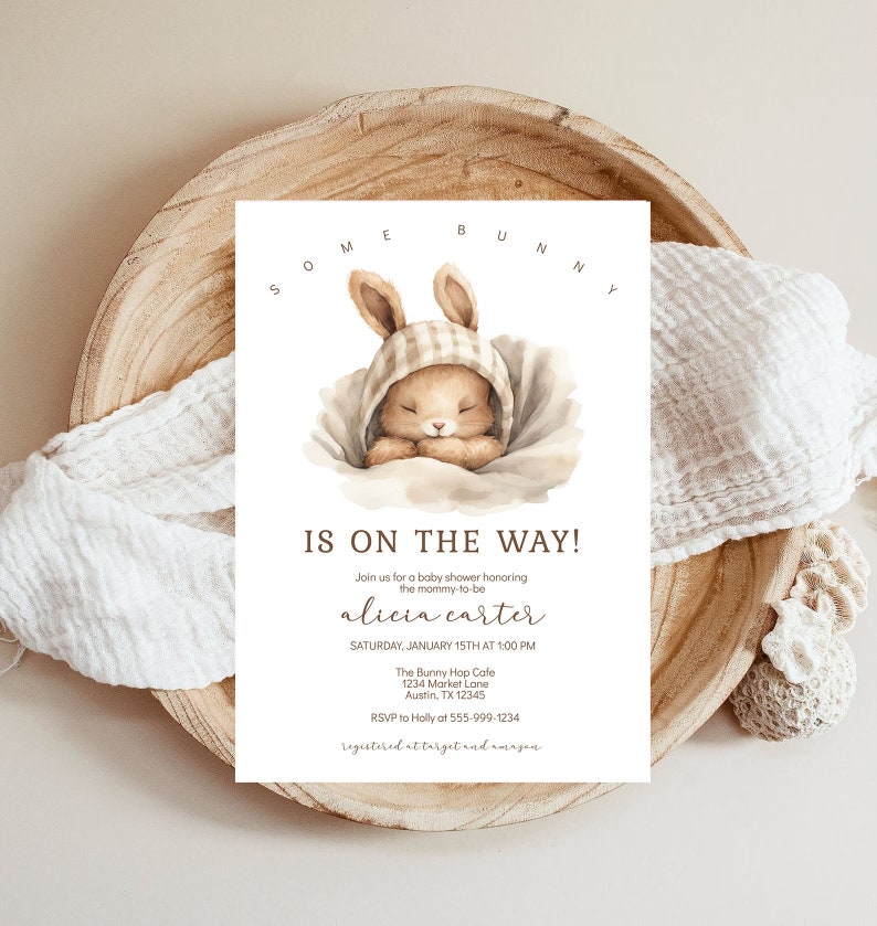 May include: A baby shower invitation with a watercolor illustration of a sleeping bunny wearing a plaid bonnet. The text reads "Some Bunny Is On The Way!" and includes the name "alicia carter" and details for the event.