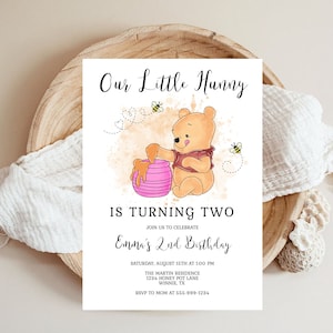 May include: A Winnie the Pooh-themed birthday invitation with a cartoon illustration of Winnie the Pooh holding a pot of honey. The invitation is for a 2nd birthday party and includes the text "Our Little Hunny is Turning Two" and "Emma's 2nd Birthday".