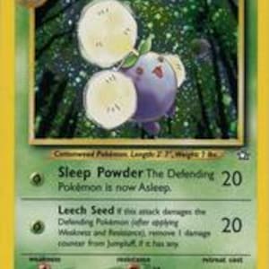 Puede incluir: Una carta coleccionable de Pok&eacute;mon Jumpluff, con borde verde y fondo amarillo. La carta presenta una criatura morada y blanca con un tallo verde y dos grandes cabezas de semillas esponjosas. El texto de la carta incluye las habilidades "Sleep Powder" y "Leech Seed".