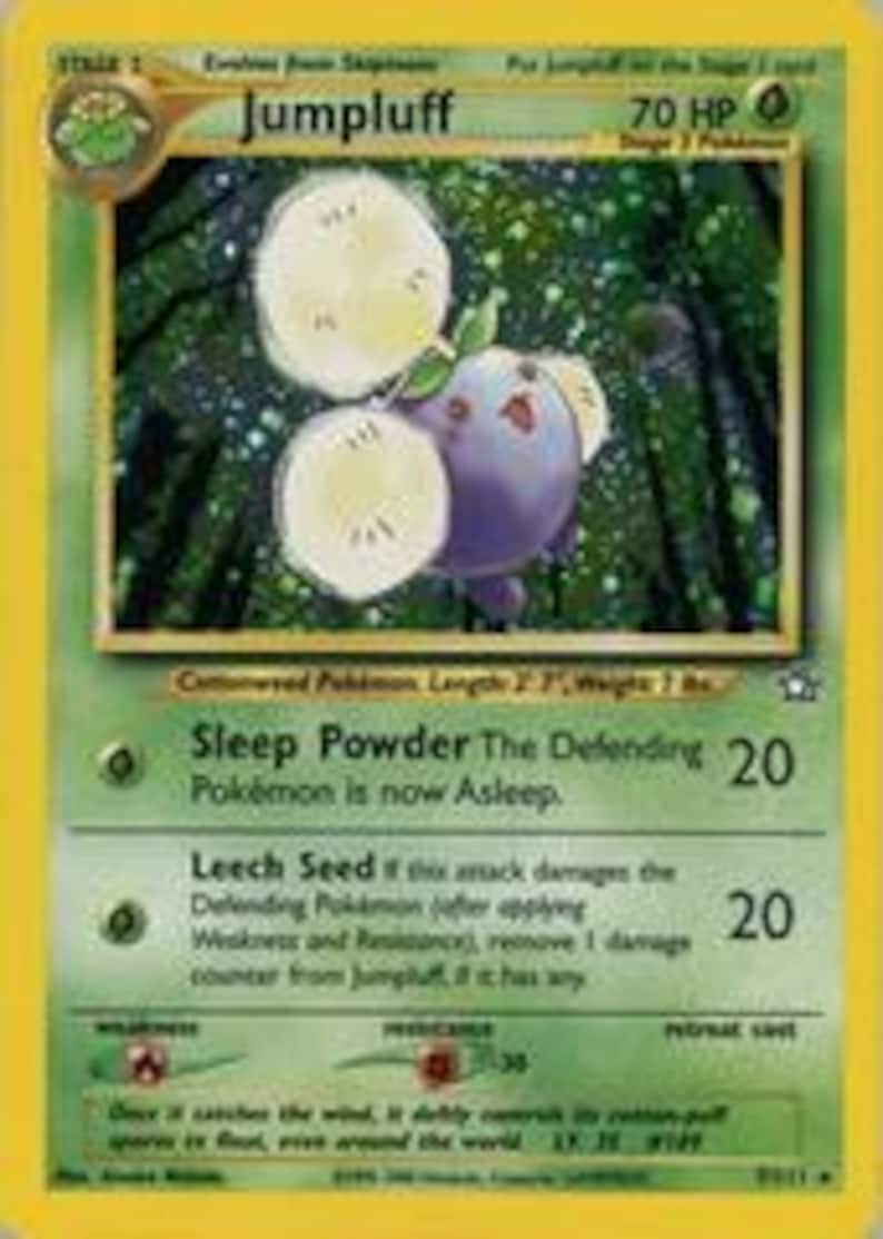 Puede incluir: Una carta coleccionable de Pok&eacute;mon Jumpluff, con borde verde y fondo amarillo. La carta presenta una criatura morada y blanca con un tallo verde y dos grandes cabezas de semillas esponjosas. El texto de la carta incluye las habilidades "Sleep Powder" y "Leech Seed".