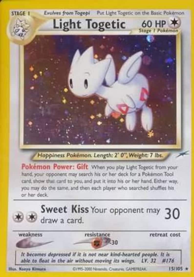 May include: A Light Togetic Pok&eacute;mon trading card. The card features a white Togetic with red markings, set against a starry background. The card has text that includes the Pok&eacute;mon's name, HP, and attack details. The card is 2 feet long and weighs 7 lbs.