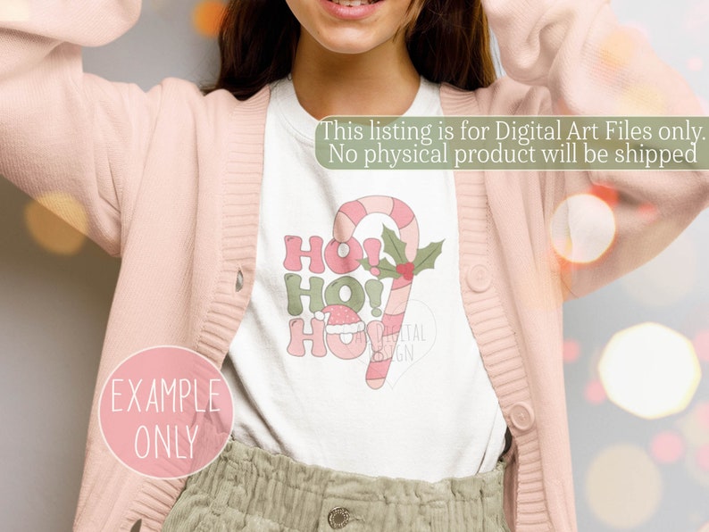 May include: A white t-shirt with a green, red, and white candy cane design and the text "Ho! Ho! Ho!" printed on it. The text is in a retro style font. The t-shirt is being worn by a person.