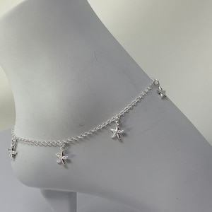 May include: Silver ankle bracelet with five dangling starfish charms.