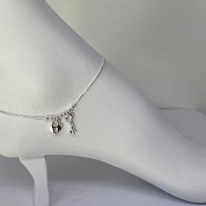 May include: Silver anklet with a heart-shaped padlock and a key charm.