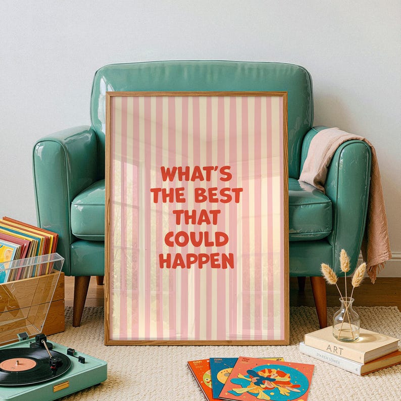 May include: A framed poster with the text "WHAT'S THE BEST THAT COULD HAPPEN" in red, set against a pink and cream striped background. The poster is displayed in a room with a teal armchair, a record player, and vinyl records.