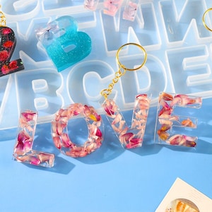 Puede incluir: Un juego de tres tazas de cerámica con acabado moteado y mate. Las tazas son de color crema, gris claro y gris oscuro. Cada taza tiene un diseño simple y minimalista.