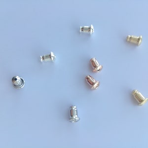 May include: Assortment of earring backs in silver, gold, and rose gold.