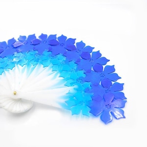 Könnte beinhalten: Ein blauer und weißer Fächer mit floralem Muster. Der Fächer ist aus Papier und hat einen Holzgriff.