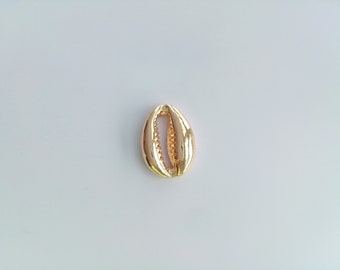 May include: A gold-colored cowrie shell charm. The shell is smooth and shiny, with a small hole drilled through the top.