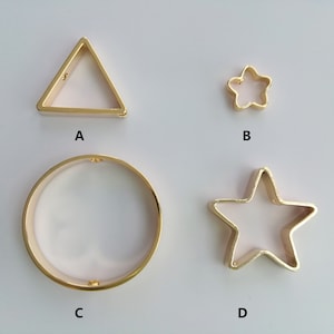 May include: Four gold-colored metal shapes: a triangle, a star, a circle, and a larger star. The shapes are labeled A, B, C, and D.