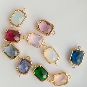 Puede incluir: Surtido de conectores de piedras preciosas de vidrio de colores con engastes de metal dorado. Los conectores tienen forma de rect&aacute;ngulos con esquinas redondeadas y un dise&ntilde;o facetado. Los colores incluyen rosa, azul, verde, morado, rojo y transparente.
